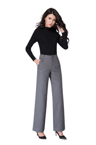 Woman in black turtleneck and gray wide-leg trousers posing in studio.